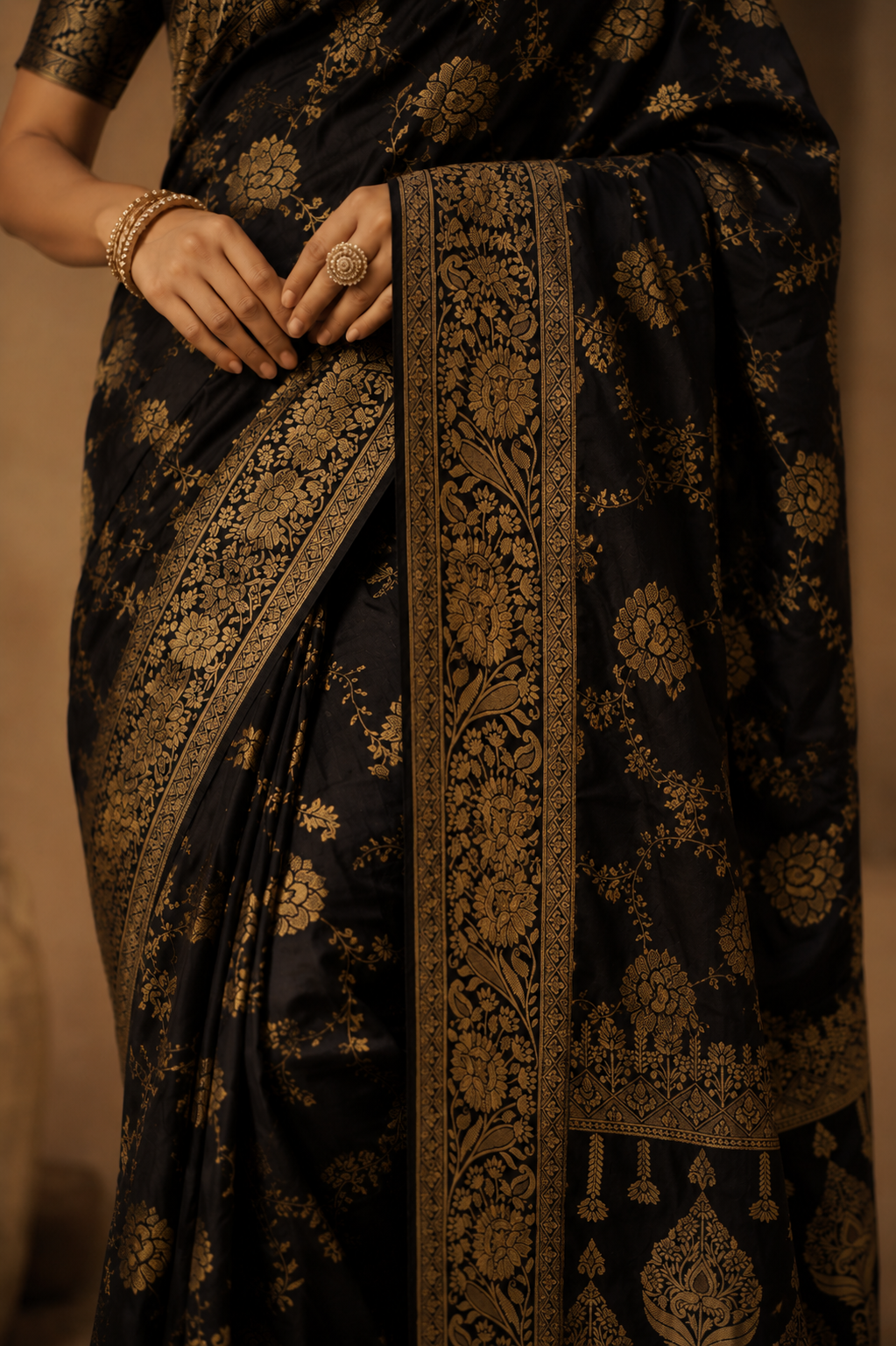Close-up of black Dola silk saree highlighting antique gold zari floral border and premium weave.