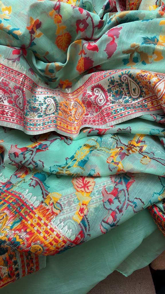 Close-up detail of the colorful woven motifs and patterned pallu on the Green Chanderi silk jacquard saree.