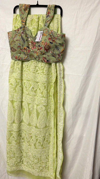 Close-up of a light green pure georgette saree showcasing intricate white floral embroidery, paisley motifs, and detailed embroidered border.