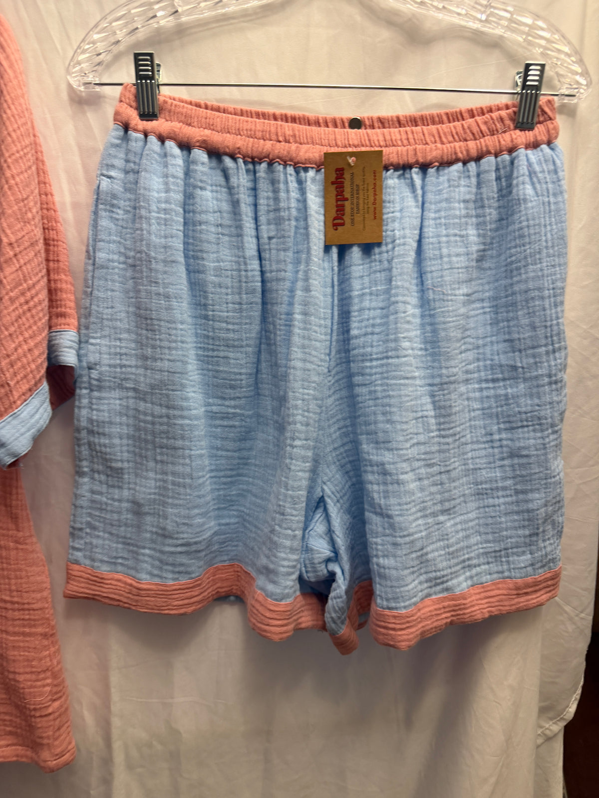 Powder blue double gauze muslin cotton shorts with dusty rose trim and a comfortable elastic waistband.
