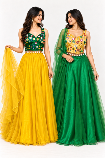 Two women modeling sleeveless floor-length traditional gowns against a plain light background. The woman on the left wears a dark green gown with a yellow tulle skirt and holds a matching yellow dupatta.