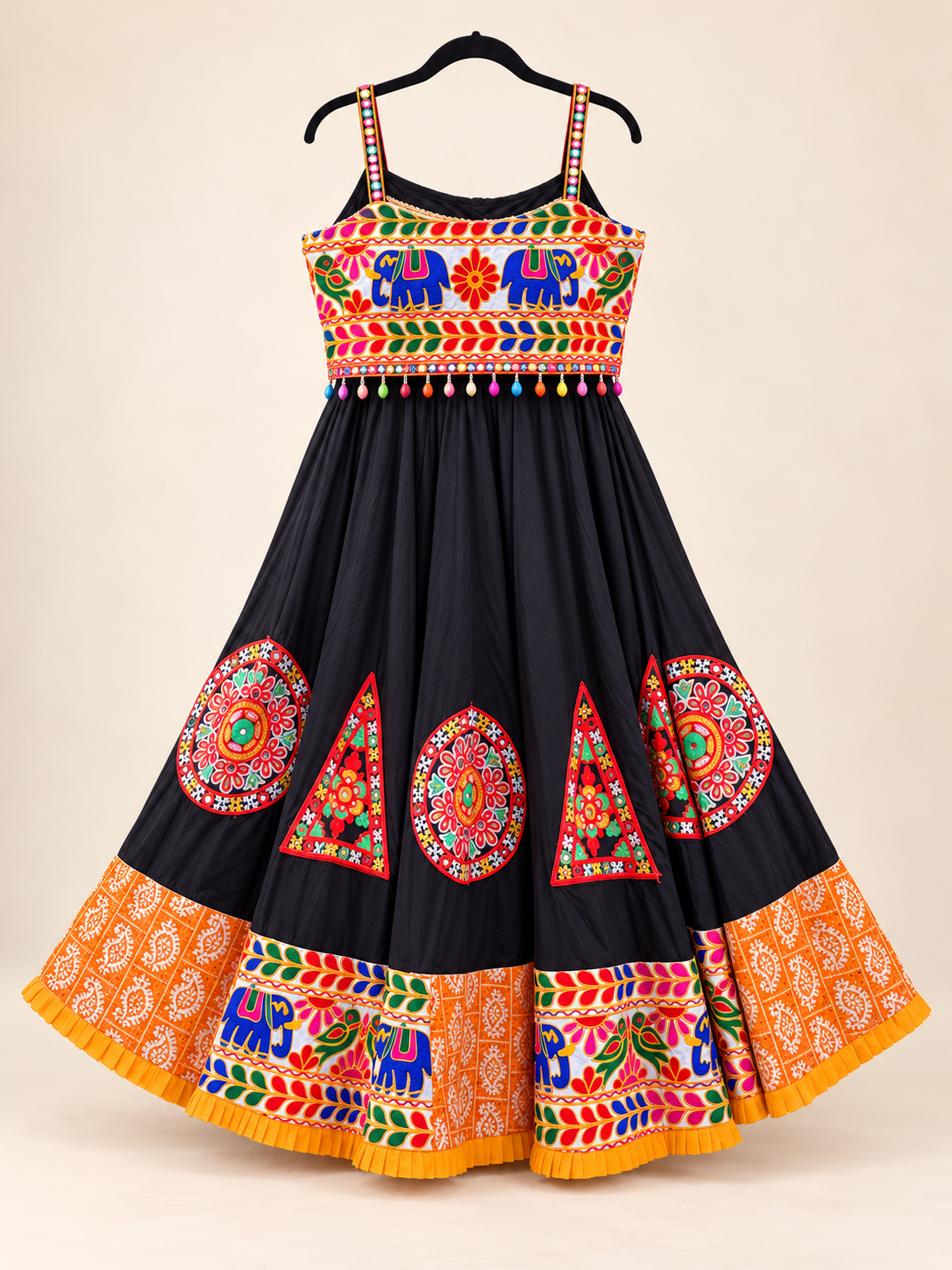 Black chaniya choli skirt with a generous full flare, multicolor embroidery, and wide orange printed ruffled border.
