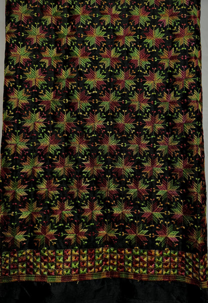 Close-up of jet black Chinnon fabric with multicolor Phulkari-style embroidery