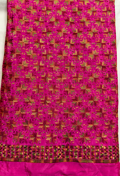 Close-up of magenta Chinnon fabric with multicolor Phulkari-style embroidery