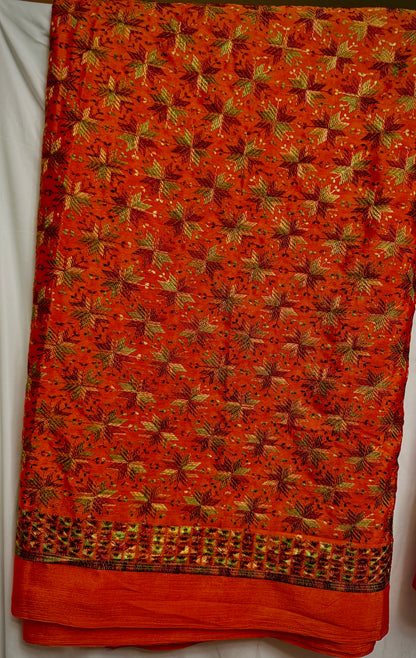 Close-up of orange Chinnon fabric with multicolor Phulkari-style embroidery