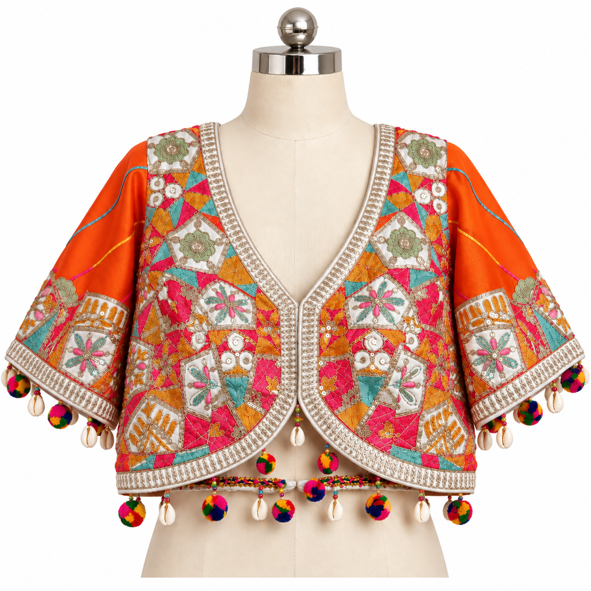 An orange cropped jacket with intricate multicolor embroidery, bead borders, and colorful tassels, displayed on a cream-colored dress form mannequin against a white background.