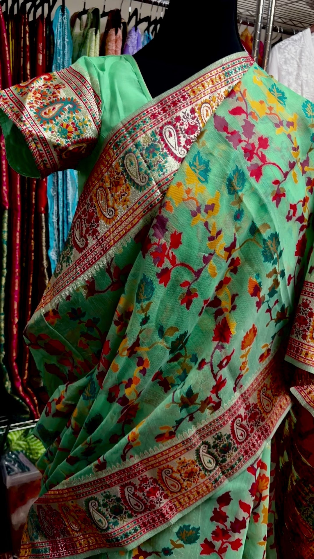 Detailed view of the saree's GreenChanderi silk jacquard fabric with traditional floral and geometric motifs.