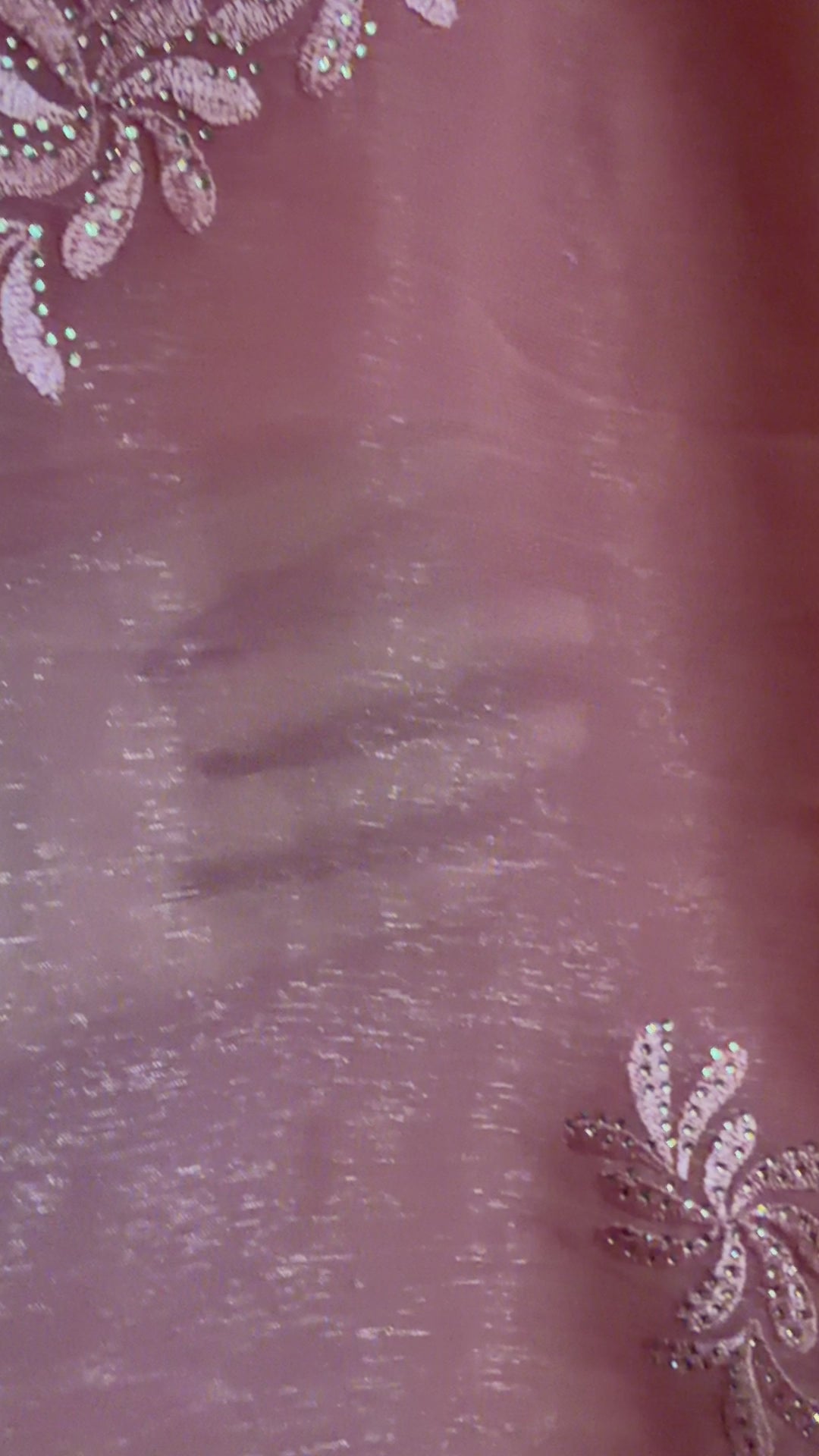 Close-up of peach shimmer tissue chiffon saree fabric showing its soft luminous finish