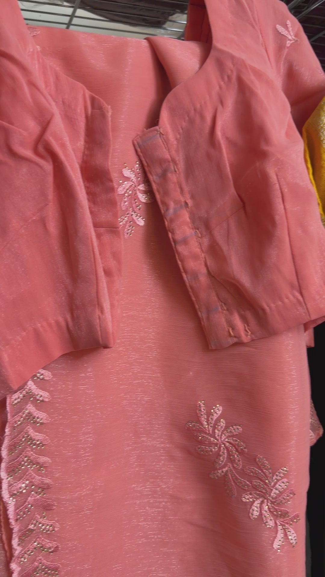 Close-up of peach shimmer tissue chiffon saree fabric showing its soft luminous finish